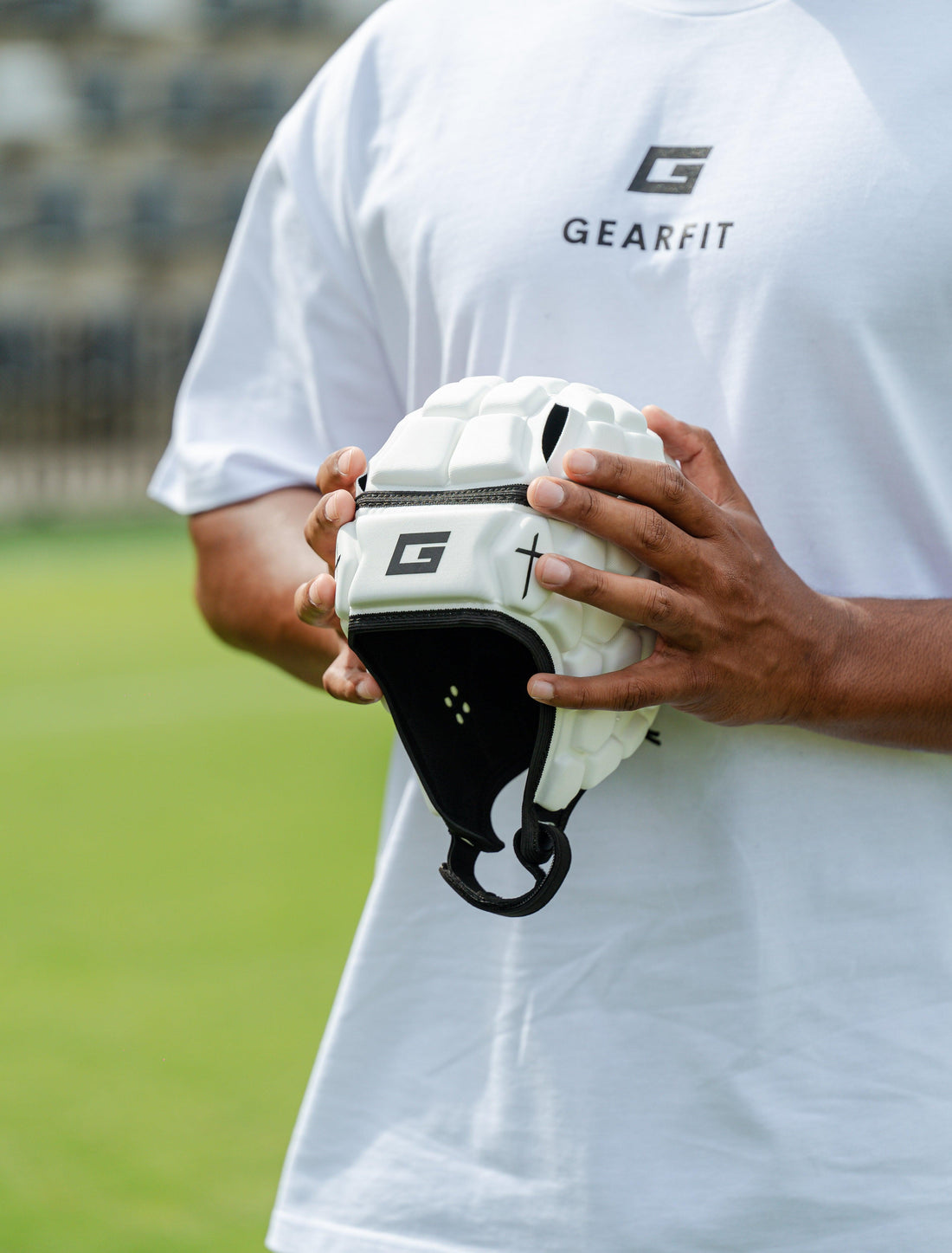 GearFit Invictus rugby headgear in white with black cross design, lifestyle photo