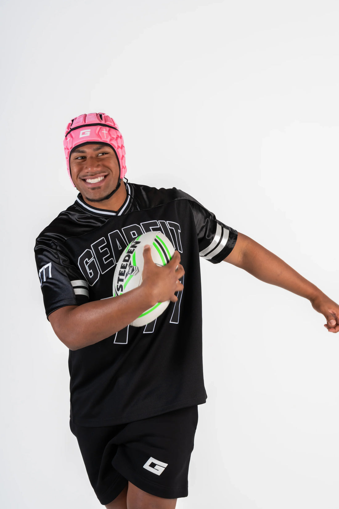 GearFit Virtue rugby headgear in pink and black with cross design, lifestyle photo