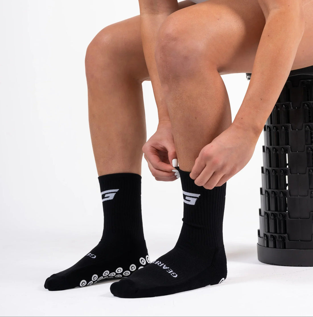 GearFit Legacy grip socks in black with cross design, alternate lifestyle photo